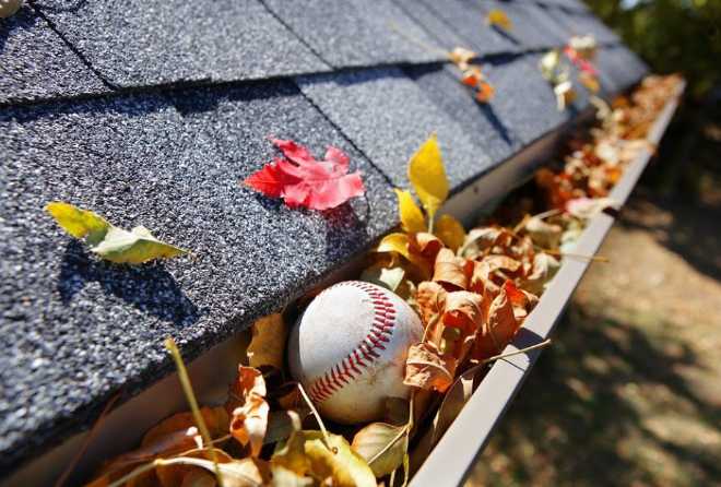 DPI Pressure Washing - roof gutter filled with old leaves and a baseball ball